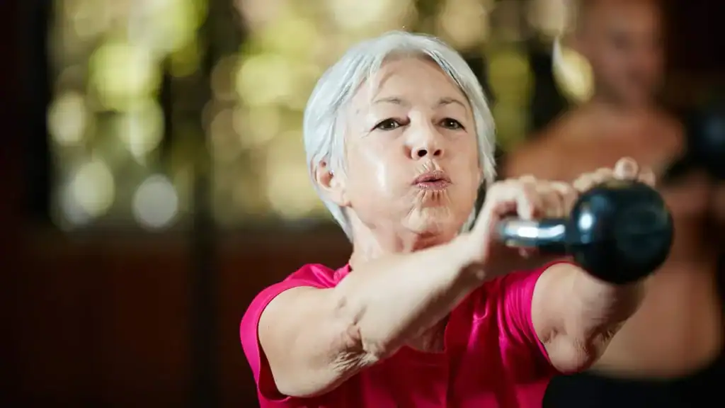 Older woman doing weight training Llanelli to help her strength and longevity 